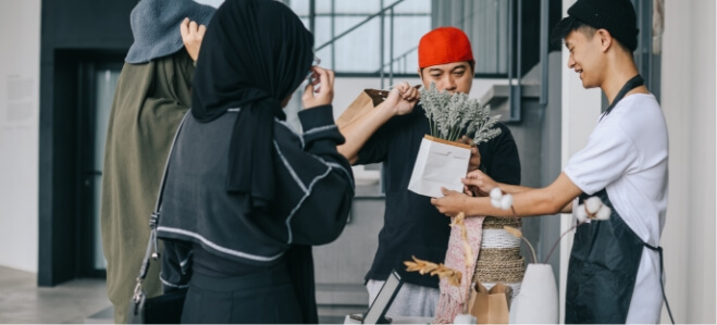 Fashion team collaboratively fitting and adjusting an outfit on a mannequin during a design session.